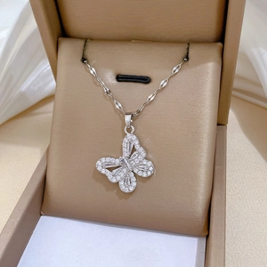 Macro detail of hollow butterfly pendant with sparkling cubic zirconia in beige jewelry box