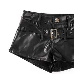 Detail von schwarzen Kunstledershorts mit passendem Gürtel und silberner Schnalle