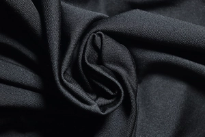 Dettaglio macro del tessuto a maglia nera con trama elastica e struttura in fibra morbida