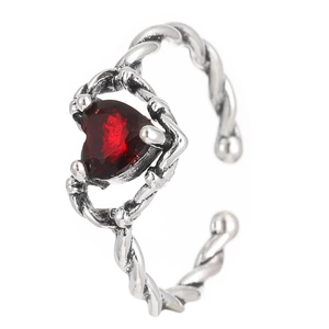 Detail of vintage silver ring with red heart gemstone and twisted metal band design