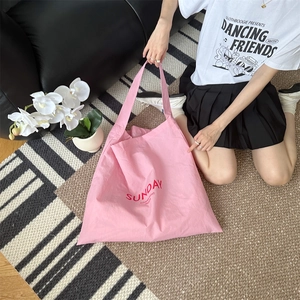 Detailed view of pink canvas tote bag with red summer lettering on a home background