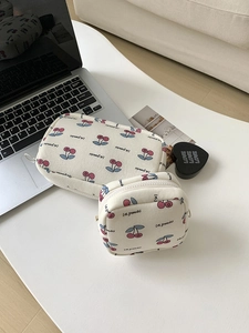 Detail shot of canvas cherry print makeup bag set showing small and large pouches