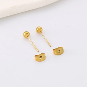 Polished gold stainless steel ball stud earrings with butterfly backs on white background