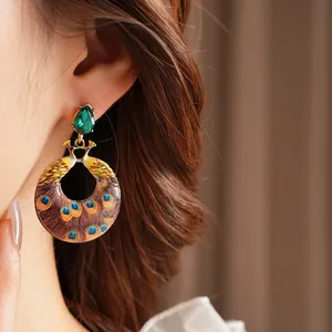 Vintage gold peacock earrings with green teardrop gemstones and colorful enamel details