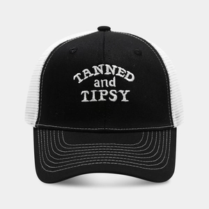 Detail of white TANNED and TIPSY embroidery on black breathable mesh trucker cap