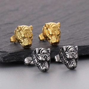 Macro shot of tiger head stud earrings in polished gold and silver stainless steel