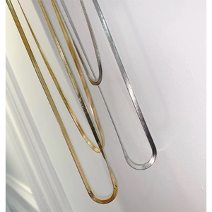 Detailed view of layered gold and silver snake bone chains with metallic gloss