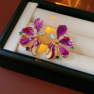 Nahaufnahme von Vintage-Blumenohrringen mit lila Emaille und Edelsteinen in der Box