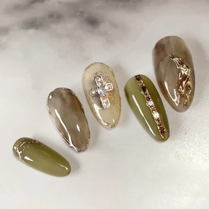 Olive green and marble nail art press-ons with gold cross and chain charms decorations