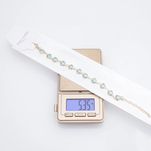 Detailed shot of a gold-plated heart bracelet on a scale showing 5.35g weight