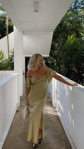 Détail de la texture d'une robe en satin vert olive avec fente latérale et col en V