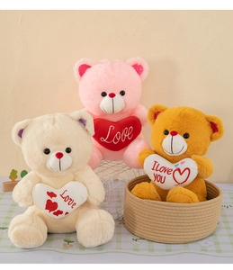 Three teddy bears in pink, cream and brown colors holding plush heart pillows with Love text