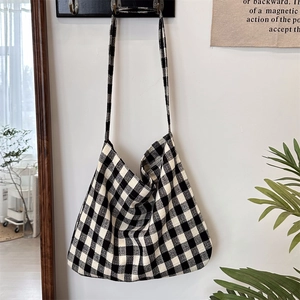 Detail of checkered canvas tote bag texture with wide strap and spacious design