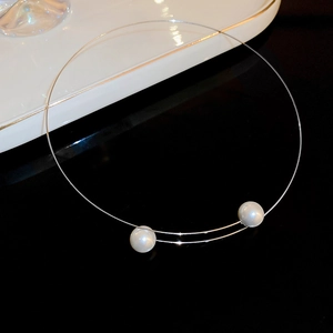 Collier ras du cou minimaliste en fil métallique avec deux perles sur fond noir poli