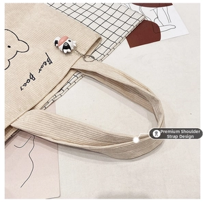 Detail view of the reinforced corduroy shoulder strap on a beige bear canvas tote bag