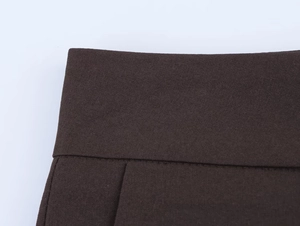 Macro view of dark brown woven blazer fabric showing high-density waist stitching details