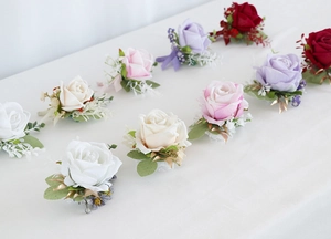 Detailed set of multi-color artificial rose corsages with greenery and lace accents