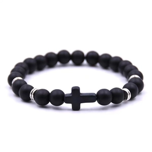 Close-up of matte black beads bracelet featuring a central cross pendant and silver spacers