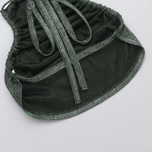 Close-up of metallic knit fabric showing the glitter texture and pleated shoulder strap detail