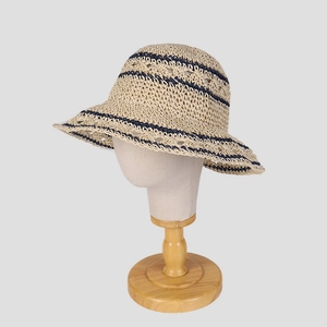 Faltbarer beige Häkelstrohhut mit blauen Streifen auf einem Hutständer für Damen