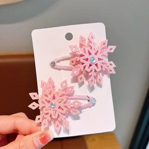 Close-up of pink glittery snowflake hair clips with rhinestones on a display card