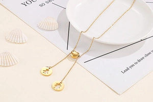 Détail du collier en Y doré avec fermoir coeur et pendentifs garçon et fille