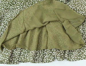 Détail de la robe verte à pois montrant la doublure en mousseline olive et coutures
