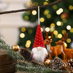 Detail of red polka dot knitted gnome pendant hanging on a festive Christmas tree branch