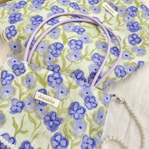 Dettaglio della borsa floreale con etichetta Sozakka e tracolla di perle eleganti