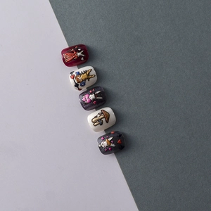 Close-up of 3D embossed nail art stickers with Alice in Wonderland rabbit and heart motifs