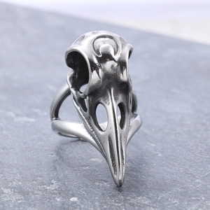 Macro shot of vintage silver bird skull ring with gothic punk design on dark stone