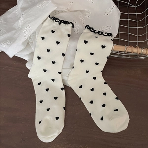 Sweet cream mid-calf socks featuring black heart patterns and delicate lace trim ruffles