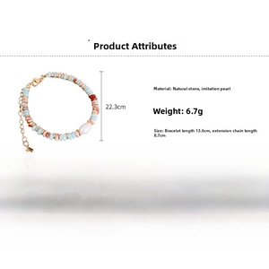 Detailed view of colorful natural stone beaded bracelet with a white faux pearl pendant