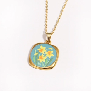 Detail of vintage golden square pendant featuring a blue narcissus floral oil painting pattern