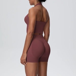 Detail view of brick red yoga set showing high waist shorts with push-up design and halter top