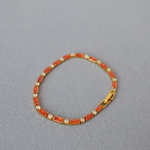 Elegant gold plated brass bracelet featuring rectangular orange zircons and round crystals