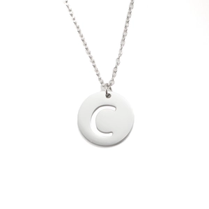 Détail macro d'un collier en acier inoxydable argenté avec pendentif lettre C ajouré