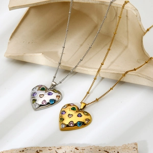 Macro detail of 18k gold heart pendants with colorful zircon on beaded chain necklaces