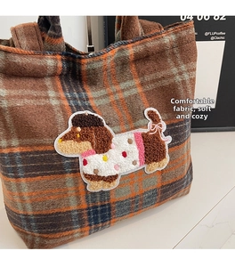 Detail of wool plaid tote bag featuring a cute cartoon dachshund plush embroidery patch
