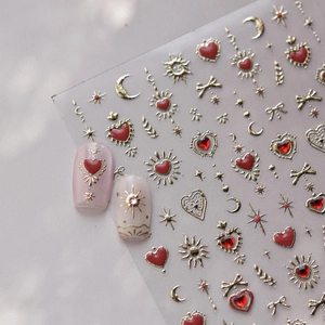 Detail view of gold and red nail art stickers with hearts, moons, stars and bows