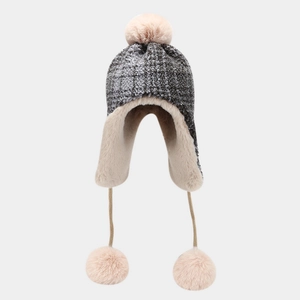 Winter faux fur trapper hat with knit ear flaps and three decorative pom poms in dark grey