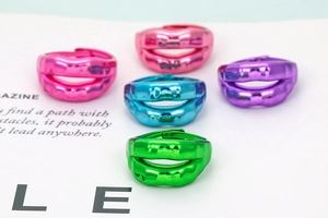 Close-up of stylish lip-shaped colorful metal rings in pink blue purple and green