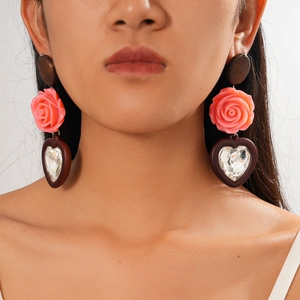 Boucles d'oreilles bohèmes rétro en bois et résine avec roses roses portées par mannequin
