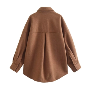 Détail du dos d'une veste en laine marron avec un pli creux et une texture de tissu