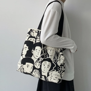 Detail of canvas tote bag featuring black and white hand-drawn artistic character prints