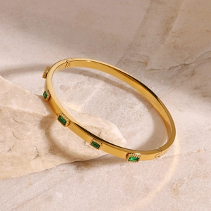 Gold stainless steel bangle with five emerald green rectangular zircon stones