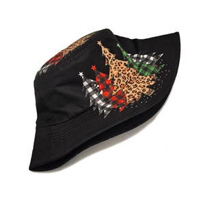 Detailed view of Christmas tree prints with plaid and leopard patterns on a black bucket hat