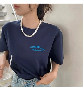 Détail du t-shirt bleu marine avec broderie bleue de texte inspirant sur la poitrine