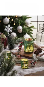 Macro detail of green glass Christmas candle holder with gold reindeer and warm LED lights