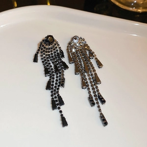 Macro detail of black zircon long tassel earrings showing silver metal backing and mesh